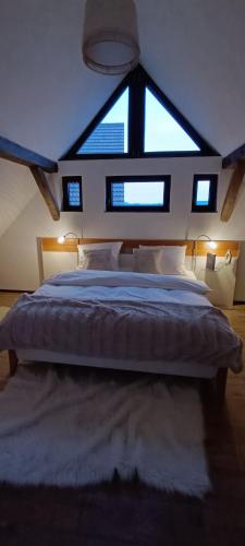 a bedroom with a large bed with a large window at Woodlight Loft - Sauna & Nature Escape near Rothenburg ob der Tauber - Self Check-in in Diebach
