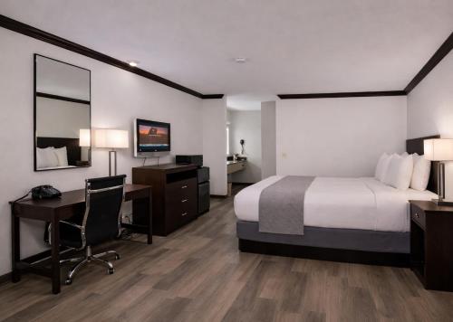 a hotel room with a bed and a desk and a computer at Discovery Inn in Midvale