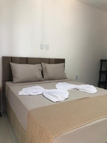 a bed with white sheets and towels on it at Pousada casa sonho do mar in Fortim