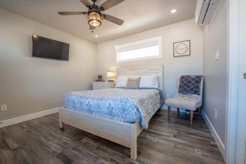 a bedroom with a bed and a ceiling fan and a chair at Red Rock Views Tiny Suite Kanab Basecamp in Kanab