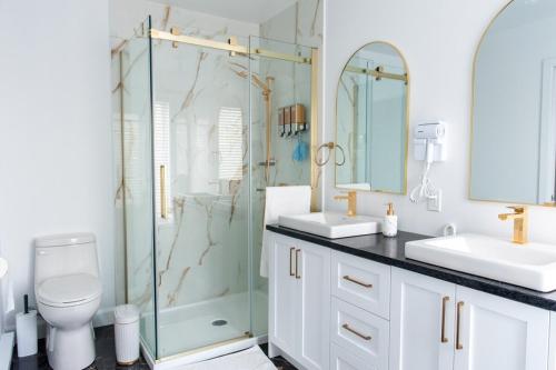 a bathroom with two sinks and a glass shower at Cozy Cottage, The Getaway in Quebec in Brownsburg
