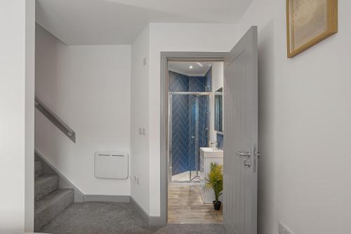 a hallway with white walls and a stairway with a door at Regent Apartments, York in York