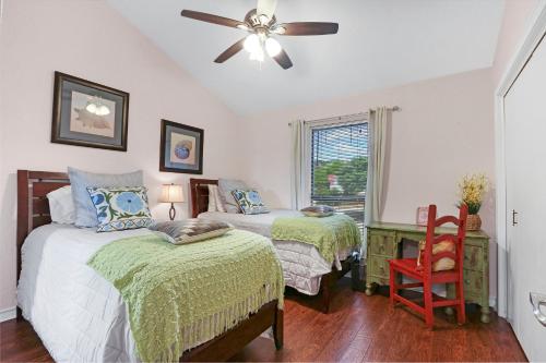 a bedroom with two beds and a ceiling fan at Cozy Glimmer in Canyon Lake