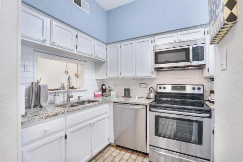 a kitchen with white cabinets and a stove top oven at Cozy Glimmer in Canyon Lake