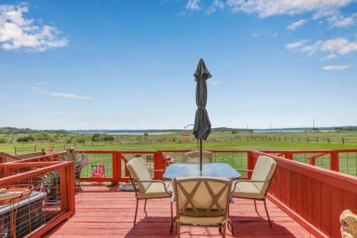 a patio with a table and chairs on a deck at Cozy Glimmer in Canyon Lake