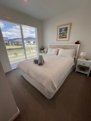 a bedroom with a large bed with a large window at Sea Escape in Whitianga