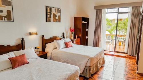 a hotel room with two beds and a balcony at Hotel Antigua Comayagua in Comayagua