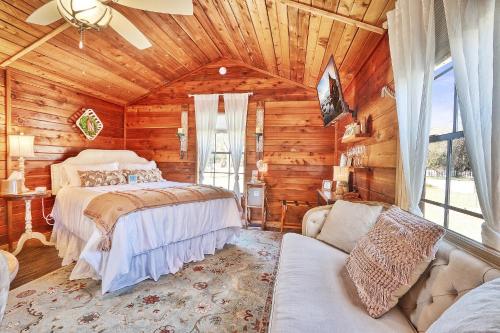 a bedroom in a log cabin with a bed and a couch at Creekside Cabins - The Nest in Wimberley