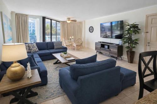 a living room with blue couches and a table at Beachfront Resort with Heated Pool Saida Royale 9039 in South Padre Island