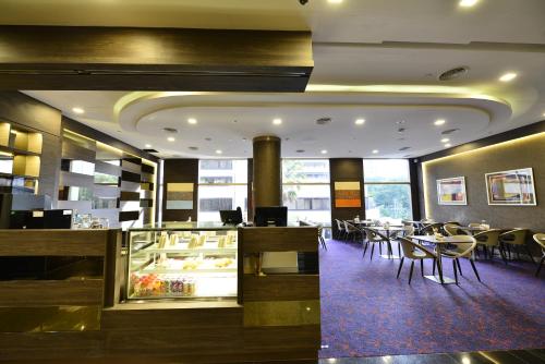 a restaurant with a dining room with tables and chairs at Hotel Grand Central in Singapore