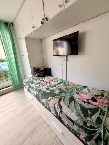 a bedroom with a bed with a tv on the wall at Le Studio Morny in Deauville