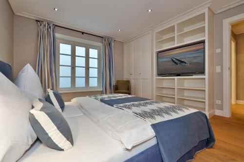 a bedroom with a large bed and a flat screen tv at Sand Beach in Rantum