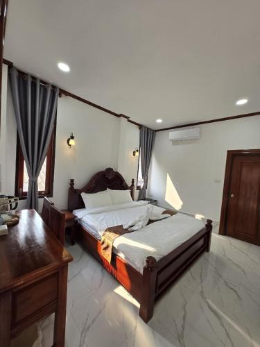 a bedroom with a bed and a desk in it at Villa ThreeD Xaydara in Luang Prabang
