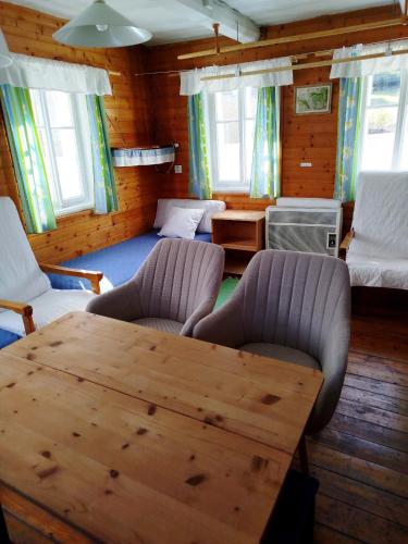 a living room with a wooden table and chairs at Chalupa u Evy in Smržovka