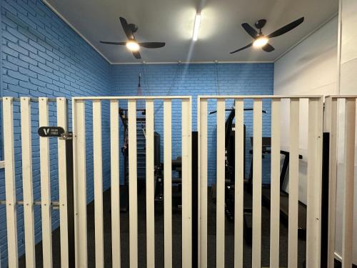 a fence in a room with two ceiling fans at The Reserve Hotel in Sale