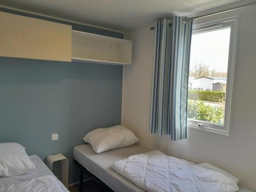 a small room with two beds and a window at Breebos Chalet near Antwerp Camp in Rijkevorsel