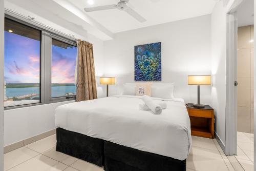 a white bedroom with a large bed and a window at Reef-side Splendour City Vistas - Pool - Workspace in Darwin