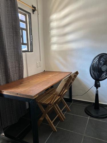 a desk with a chair and a fan in a room at Estudio De La Cinco Puerto Vallarta in Puerto Vallarta