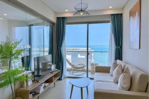 a living room with a couch and a view of the ocean at The Song Luxury Near Beach Apartment - Căn hộ Nghỉ Dưỡng Cao Cấp Cạnh Biển - Moonlight Homestay in Vung Tau