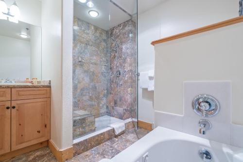 a bathroom with a shower and a tub and a sink at Bear Creek Lodge 203C Hotel Room in Telluride