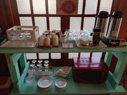 a shelf with a table with dishes and a microwave at Habitación Bosque Mar in Isla Negra