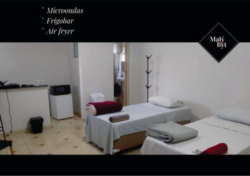 a room with two beds and a sign that says max buy at Malý Byt in São João Nepomuceno