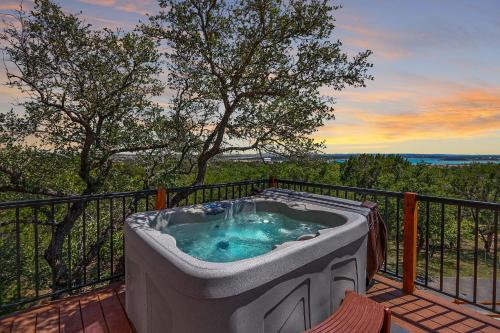 a hot tub on the deck of a house at Scenic Treehouse in Canyon Lake