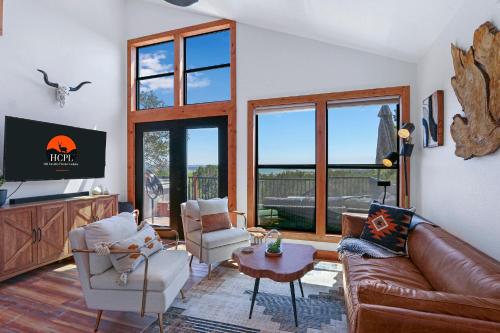 a living room with a couch and chairs and a tv at Scenic Treehouse in Canyon Lake