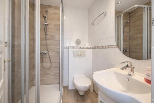 a bathroom with a toilet and a sink and a shower at Fewo Luv in Kühlungsborn