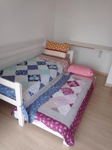 a bed with a quilt on it in a room at Casa Confort Praia dos Ingleses in Florianópolis