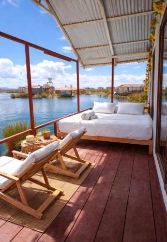 a bedroom on a deck with a bed and chairs at uros royal logde in Puno