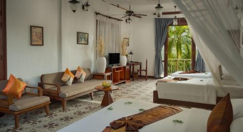 a hotel room with two beds and a tv at La Rivière d' Angkor Resort in Siem Reap
