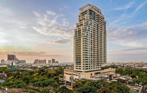 a tall building with a city in the background at Jasmine Grande Residence Suite Bangkok in Bangkok