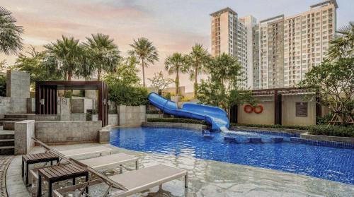 a swimming pool with a slide in a resort at Jasmine Grande Residence in Bangkok