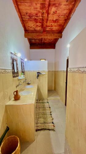 a bathroom with a sink and a wooden ceiling at Kasbah Restaurant Citoyenne in Agoudal
