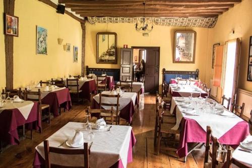 un comedor con mesas y sillas con mantel púrpura en Casa Rural Restaurante Casino Munilla, en Munilla