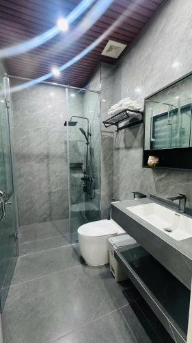 a bathroom with a shower and a toilet and a sink at Sunrise Home in Xóm Niêm
