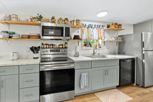 a kitchen with white cabinets and a stainless steel refrigerator at Wild Rhodes in Wimberley