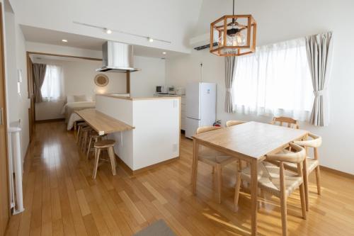 a kitchen and dining room with a table and a refrigerator at Sa one ko Matsumoto Entire house Free parking 2cars in Matsumoto