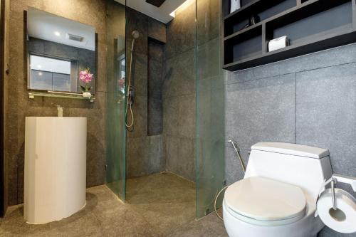 a bathroom with a toilet and a glass shower at 2BR Family Condo with a Pool View - CTG P205 in Kamala Beach