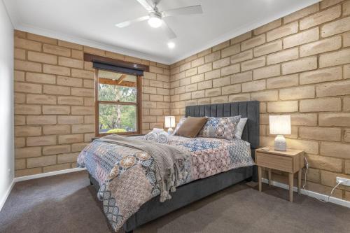 a bedroom with a bed and a brick wall at Route 86 Bright in Bright