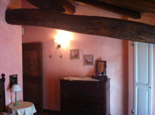 a bedroom with a dresser and a wooden beam at Agriturismo La Cascinetta in Pieve di Cento