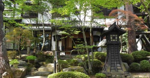 a garden with a bird house in front of a building at Hotakajo in Azumino