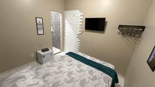 a small bedroom with a bed and a tv at Suíte aconchegante 2 in Nova Mutum