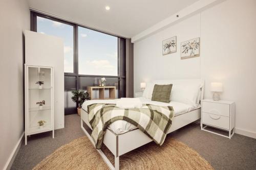 a bedroom with a bed and a large window at Two Bedroom Unit in Central Adelaide in Adelaide