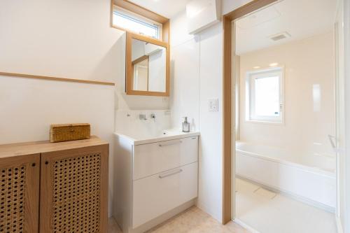 a bathroom with a sink and a tub and a mirror at Sa one ko Matsumoto Entire house Free parking 2cars in Matsumoto