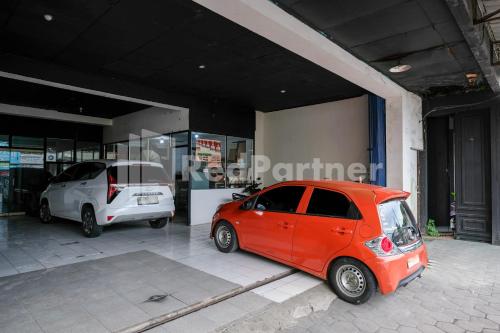 two cars parked in front of a building at Griya Aneka Malioboro Yogyakarta Mitra RedDoorz in Yogyakarta