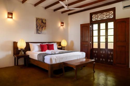 a bedroom with a bed with two lamps and a table at Saachi Lagoon Resort in Kalpitiya
