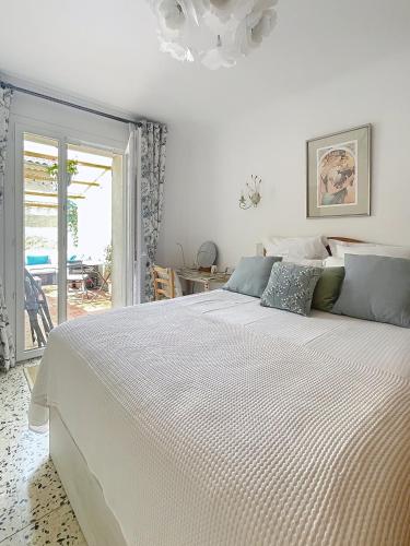 a bedroom with a large white bed with a window at Sejour paisible au Thor in Le Thor