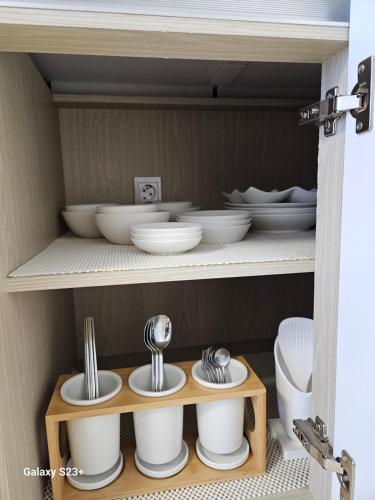 a cupboard with bowls and dishes on a shelf at Nolgureum private pool villa in Jeju